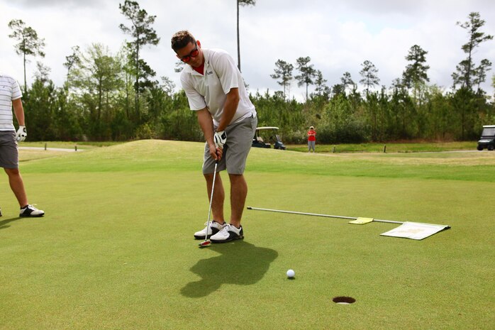 Cpl. Matthew Lemaitre, Marine Aviation Logistics Squadron 29 precision measurement equipment technician, putts his golf ball into hole four at Bear Trails Golf Course in Jacksonville, N.C. during the Marine Corps Air Station New River Marine Corps Community Services Spring Golf Tournament, April 19.
