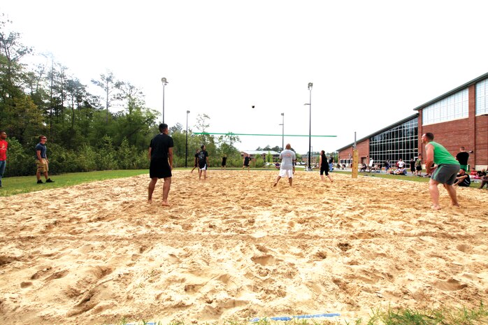 Teams of Headquarters and Headquarters Squadron await a volleyball during a game at the Commander's Cup volleyball game, April 19. 
