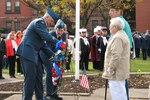 Rome community members stand while Lt. Col. Wendy Rickards, Northeast Air Defense Sector Canadian Component commander, and Warrant Officer Norm Macoomb, NEADS Canadian Component unit warrant officer, place a wreath next to the Northeast Air Defense Sector's wreath during a joint, bi-national Veterans Day ceremony in Rome, N.Y.