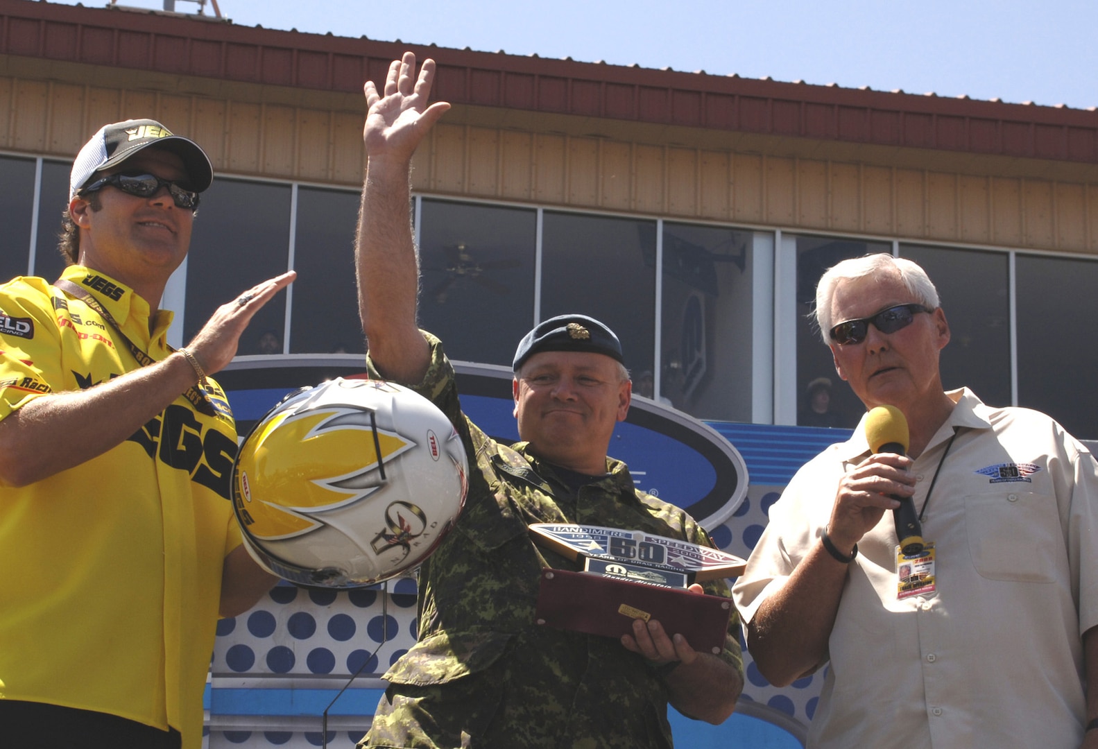Reigning Pro Stock champion Jeg Coughlin Jr., left, North American Aerospace Defense Command Deputy Commander Lt.-Gen Charlie Bouchard, center, and Bandimere Speedway president and CEO John Bandimere Jr., participate in opening ceremonies for the MOPAR Mile-High NHRA Nationals in Morrison, Colo., on July 13. Bouchard acted as an honorary starter for the day's races at Bandimere Speedway, which celebrated its 50th anniversary along with NORAD's. Photo by Canadian Forces Lt. Desmond James 