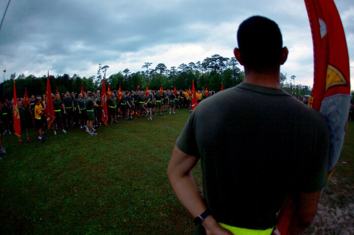 Marines and sailors with 2nd Marine Logistics Group get into formations as Sgt. Maj. George W. Young Jr., the sergeant major of 2nd MLG, prepares to speak to the servicemembers during a three-mile unit run aboard Camp Lejeune, N.C., April 25, 2013. The command staff of 2nd MLG spoke to the servicemembers about current events happening to deployed troops with the MLG and expectations for the future. 