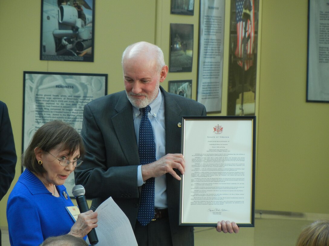 At the Marine Corps Association's 100th anniversary celebration, Virginia State Sen. Toddy Puller, daughter in law of Gen. Chesty Puller, presents a resolution passed by the Virginia General Assembly recognizing the MCA as retired Maj. Gen. Ed Usher, MCA President and CEO, looks on. The celebration was April 25, 2013, at the National Museum of the Marine Corps.