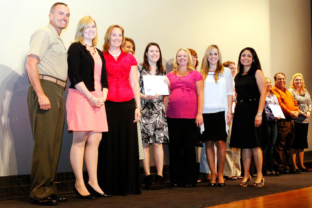 Brig. Gen. Vincent A. Coglianese, left, presents awards to recipients at the 2013 Volunteer of the Year Award Ceremony at the base theater here April 25. Coglianese is base commanding general and regional authority for five military installations in the Southwestern United States. 