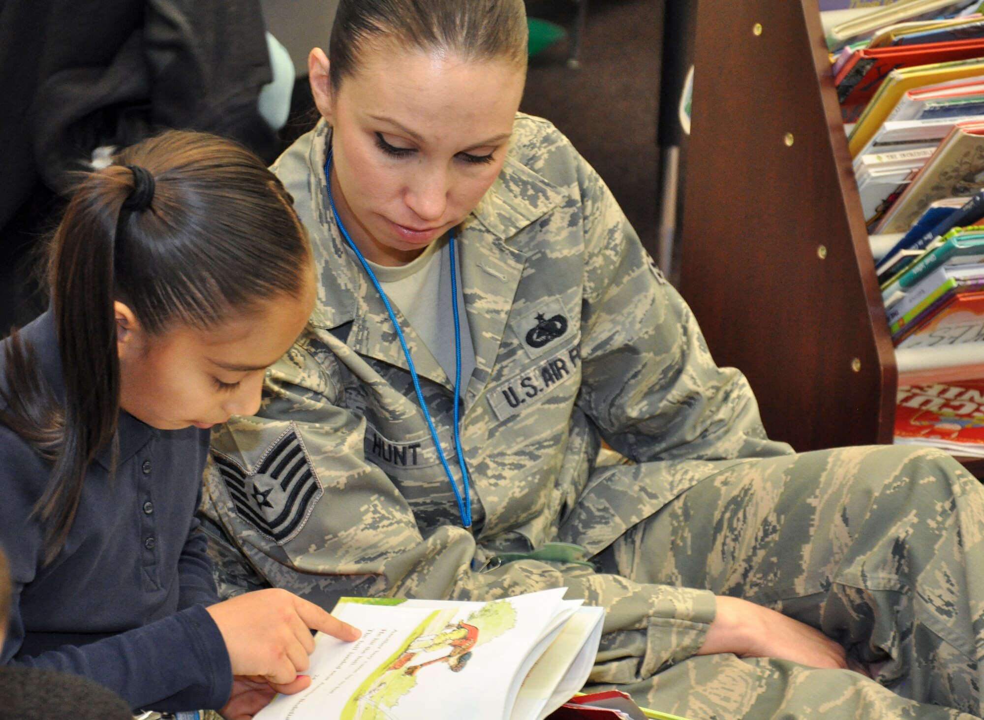 Tech. Sgt. Andrea Hunt, 460th Space Communications Squadron, helps her Power Lunch Reading Program buddy, Juana, read a new book April 19, 2013, at John H. Amesse Elementary School, Denver. Buckley Air Force Base participates in the program for the first time this year. (U.S. Air Force photo by Staff Sgt. Nicholas Rau/Released)