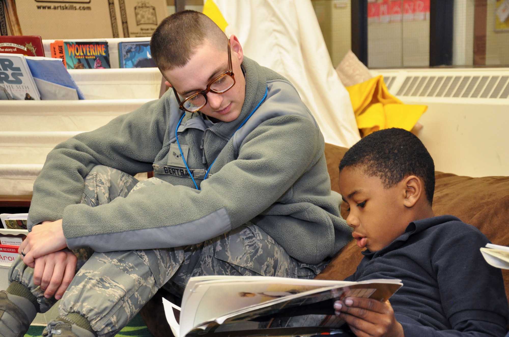 Airman 1st Class Cody Bertram, 460th Space Communications Squadron, reads with his Power Lunch Reading Program buddy, Javaun, April 19, 2013, at John H. Amesse Elementary School, Denver.  The program pairs Team Buckley members with third graders to help the students increase their reading skills. (U.S. Air Force photo by Staff Sgt. Nicholas Rau/Released)