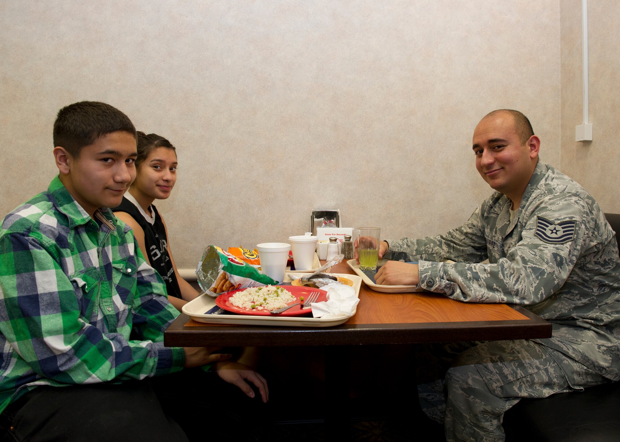 Tech. Sgt. David Aguirre, 372nd Training Squadron, Detachment 10 tactical aircraft maintenance systems instructor, has lunch with his children, Marisol and Kris, at the Shifting Sands Dining Facility during Take Your Kid to Work Day at Holloman Air Force Base, N.M., April 22. The event was held in April for the Month of the Military Child. (U.S. Air Force photo by Senior Airman Kasey Close/Released)