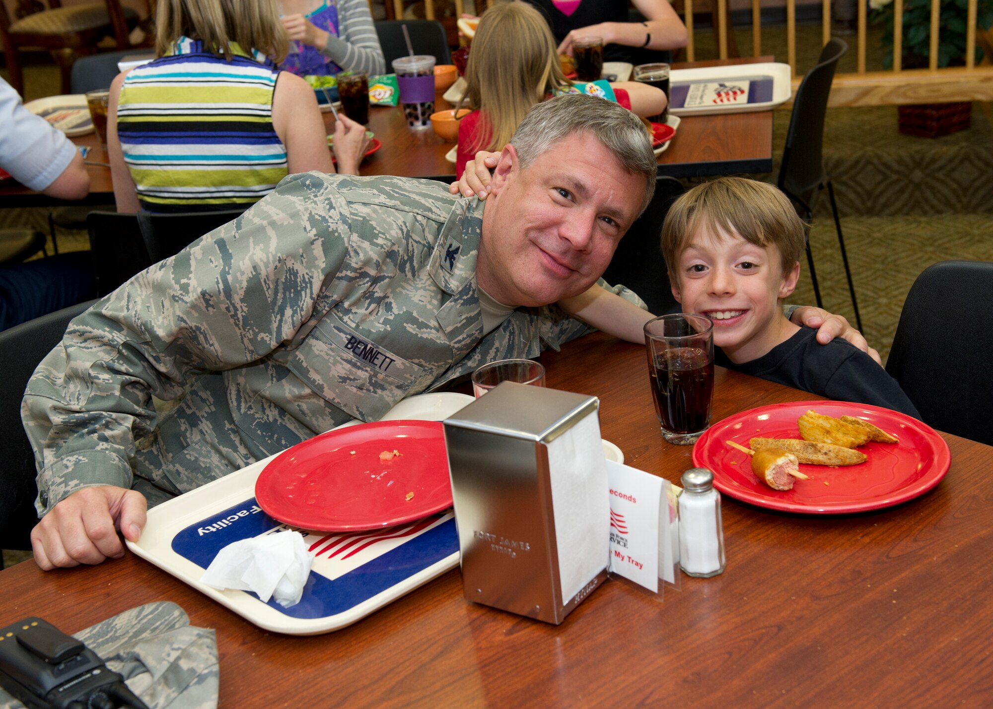 Colonel Kevin Bennett, 49th Mission Support Group commander, and his son, Alex, have lunch together at the Shifting Sands Dining Facility during Take Your Kid to Work Day at Holloman Air Force Base, N.M., April 22. Alex learned about the many responsibilities and squadrons that his father manages every day. (U.S. Air Force photo by Senior Airman Kasey Close/Released)