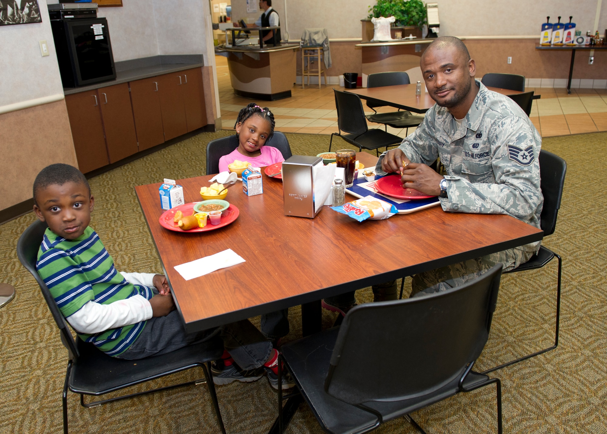 Staff Sgt. William Terry, 44th Maintenance Squadron non-destructive inspection technician, has lunch with his children, Nijah and Jayden, at the Shifting Sands Dining Facility during Take Your Kid to Work Day at Holloman Air Force Base, N.M., April 22. The children got to see where their father works and what he does for the Air Force. (U.S. Air Force photo by Senior Airman Kasey Close/Released)