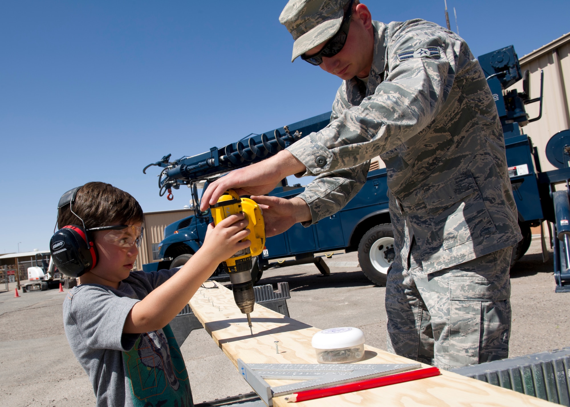 Airman 1st Class Nicholas Daniels, 49th Civil Engineer Squadron structural apprentice, assists Johnny Cavallo as he uses a drill during Take Your Kid to Work Day at Holloman Air Force Base, N.M., April 22. Johnny is the son of Master Sgt. John Cavallo, 49th CES structures NCO in charge. The event was held in April for the Month of the Military Child. (U.S. Air Force photo by Senior Airman Kasey Close/Released)