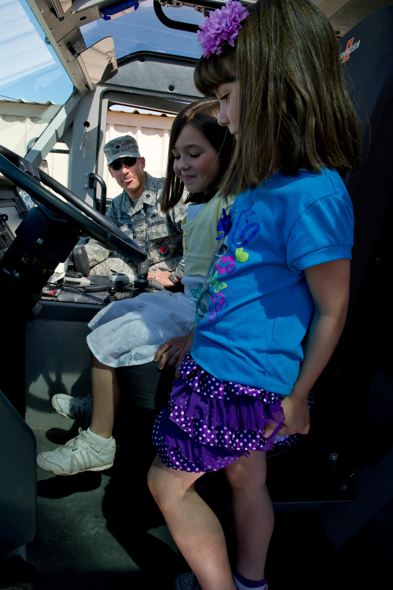 Lt. Col. Donald Ohlemacher, 49th Civil Engineer Squadron commander, teaches his daughters, Ashley and Kendall, about the P-19R Stryker Fire Engine during Take Your Kid to Work Day at Holloman Air Force Base, N.M., April 22. The 49th CES had a range of heavy equipment for the children to look at throughout the day. (U.S. Air Force photo by Senior Airman Kasey Close/Released)