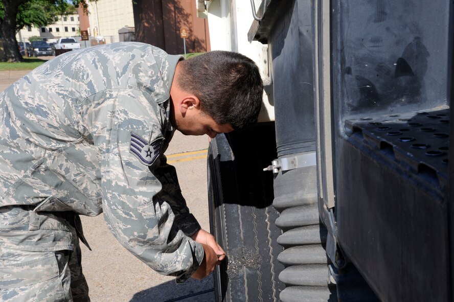 Staff Sgt. Kyle Pullum, 2nd Civil Engineer Squadron Heavy Repair section, removes a rock from his street sweeper's tire during a foreign object debris check on Barksdale Air Force Base, La., April 25, 2013. Street sweepers are not limited to just the roads of Barksdale; they are also used on the flightline to sweep for loose rocks and other objects and serve as a means of preventative maintenance.  (U.S. Air Force photo/Airman 1st Class Andrew Moua)
