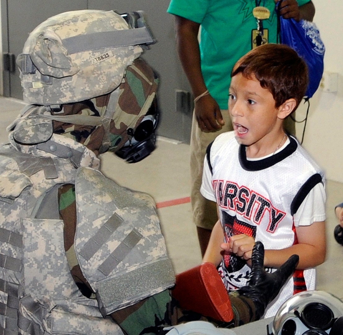 Miguel Rendon observes an Air Force member in full Mission Oriented Protective Posture gear during Operation Families Learning About Global Support in June 2011. (U.S. Air Force photo by Don Lindsey/ Released)
