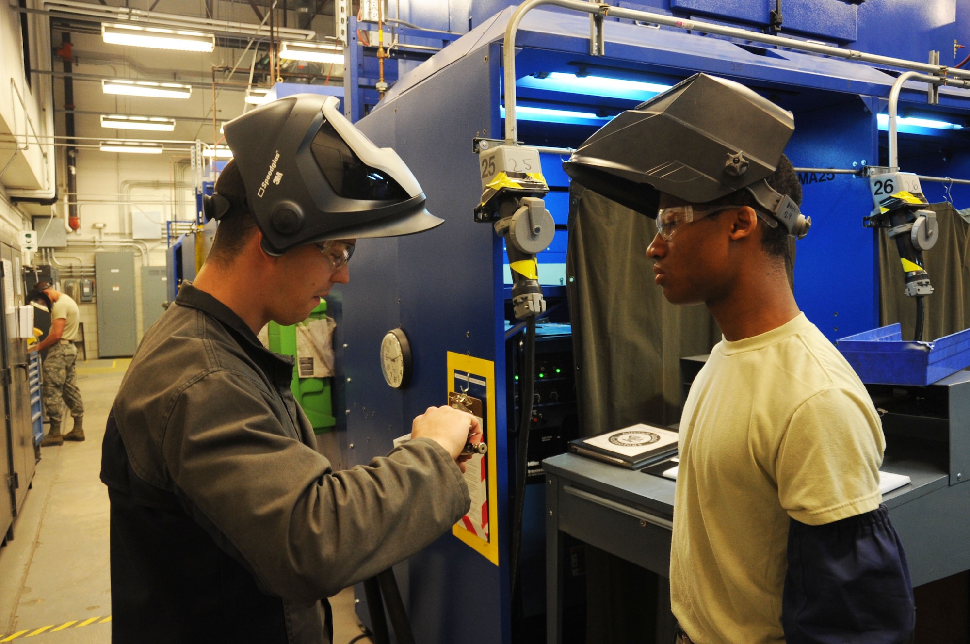 Air Force Staff Sgt. Jordan Loving (left), 361st Training Squadron aircraft metals technology instructor, reviews a tungston inert gas weld exercise with Airman 1st Class Michael Abney (right), 361st TRS Airman-in-Training, at Sheppard Air Force Base, Texas, April 25, 2013.  Loving was named the 2012 AETC Airman Instructor of the Year.  (U.S. Air Force photo by Dan Hawkins/Released) 