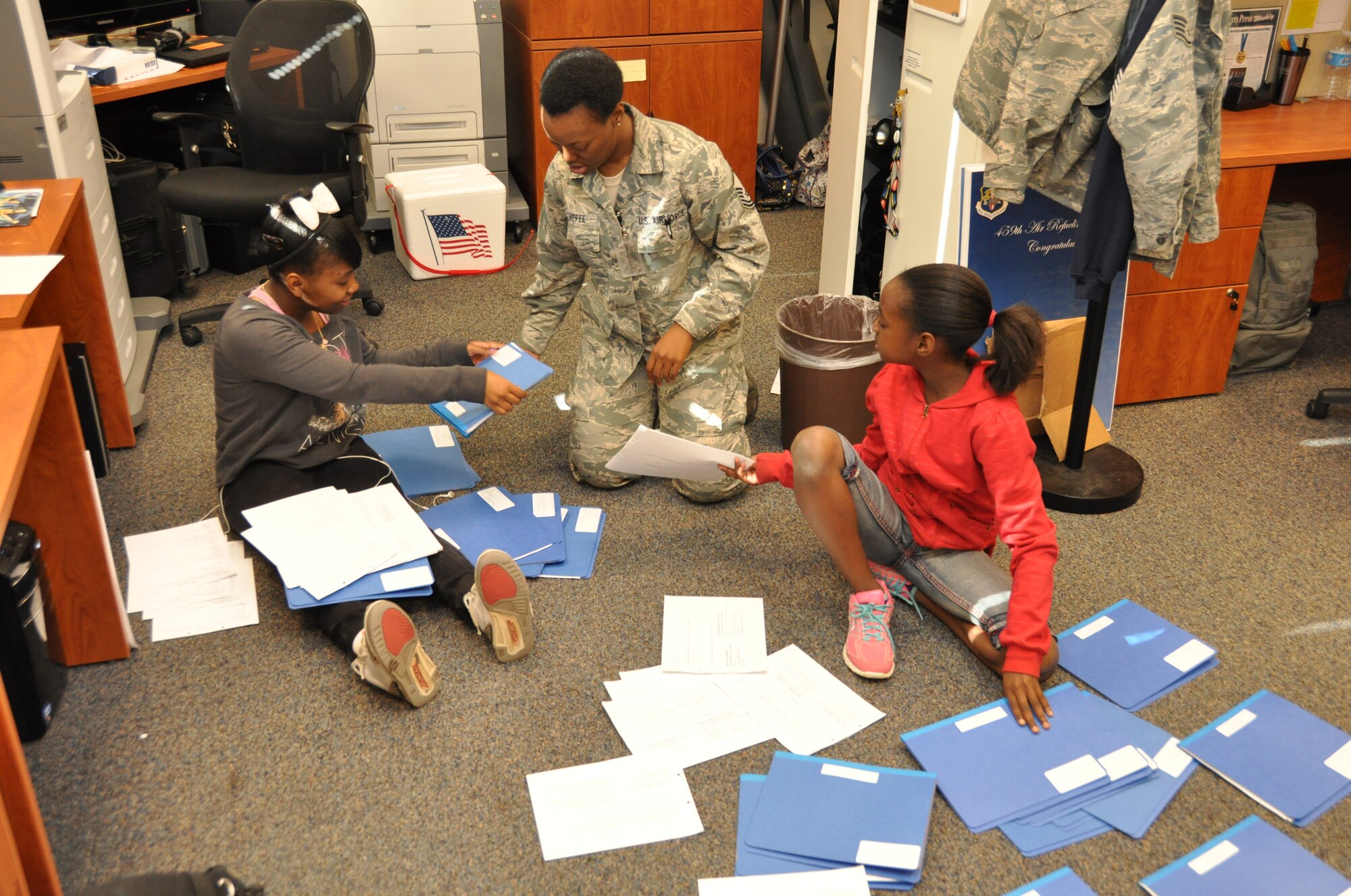 U.S. Air Force Master Sgt. Cherylene Menefee, program facilitator 459th Development and Training Flight, shows her daughters how to organize paperwork on Take Your Child to Work Day, at Joint Base Andrews, Md., April 25, 2012. Take Your Child to Work Day is a day where parents can bring their children into the workplace to highlight the different opportunities available to them and to promote a positive attitude for their future. (U.S. Air Force photo/ Staff Sgt. Katie Spencer) 