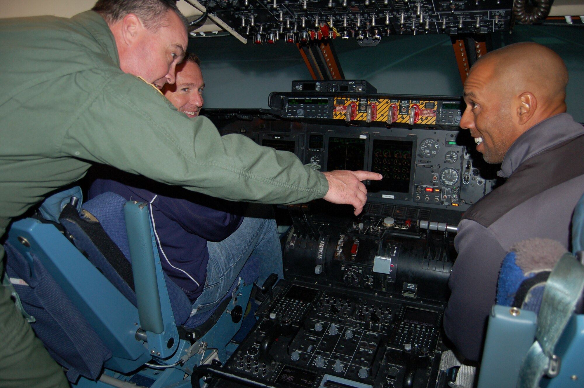Lt. Col. Gary Edwards, 433rd Airlift Wing safety officer and a C-5A Galaxy pilot, explains the vast instrumention panel to San Diego Padres' General Manager Josh Byrnes (far left) and Glen Barker, former Major League Baseball outfielder and currently the Padres' outfield/ baserunning coordinator, on a visit to the "Alamo Wing" April 24 at Joint Base San Antonio-Lackland. (U.S. Air Force Photo/Elsa Martinez) 