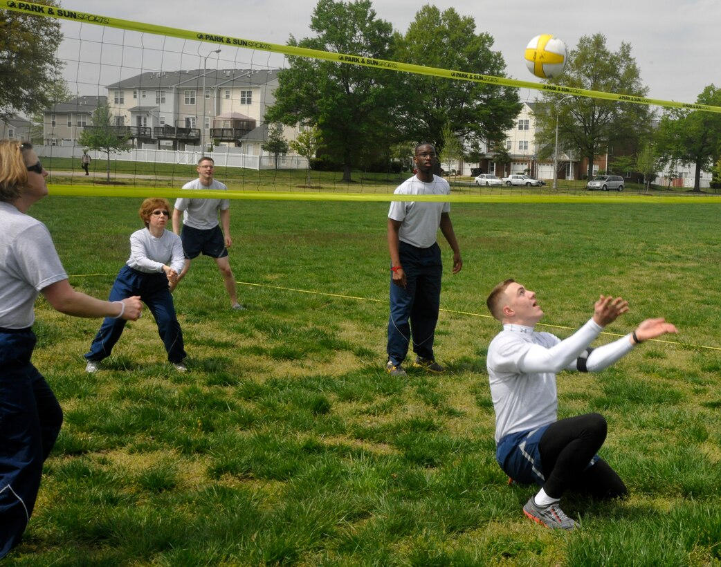 From behind his head, Airman 1st Class Brandon Clement, U.S. Air Force Honor Guard ceremonial guardsman, prevents a volley ball from touching the ground during an outdoor 11th Operations Group commander's call at Joint Base Anacostia-Bolling April 23, 2013. The commander's call was held in order to present the 11 OG's three units with their quarter and annual awards, raise money for the Air Force Assistance Fund, as well as build camaraderie and maintain the morale of all within each unit. (U.S. Air Force photo/Senior Airman Lindsey A. Porter)