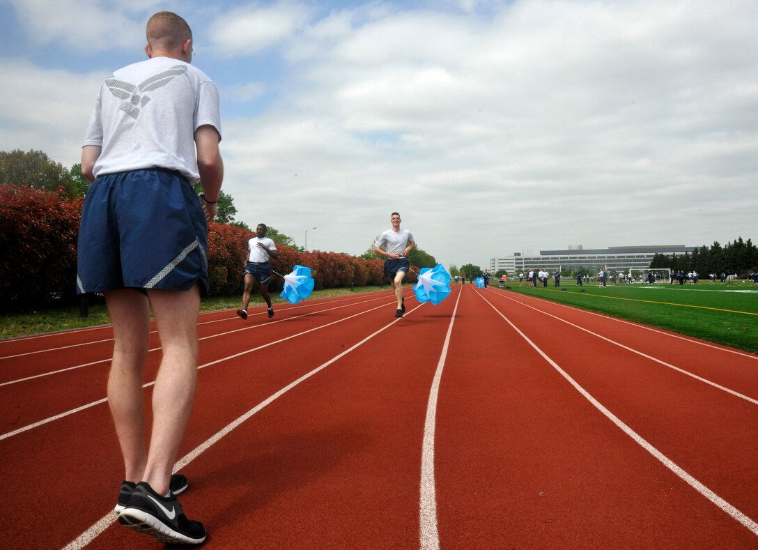 Airmen from the 11th Operations Group participate in a parachute resistant relay race during an outdoor 11th Operations Group commander's call at Joint Base Anacostia Bolling April 23, 2013. The commander's call was held in order to present the 11 OG's three units with their quarter and annual awards, raise money for the Air Force Assistance Fund, as well as build camaraderie and maintain the morale of all within each unit. (U.S. Air Force photo/Senior Airman Lindsey A. Porter)