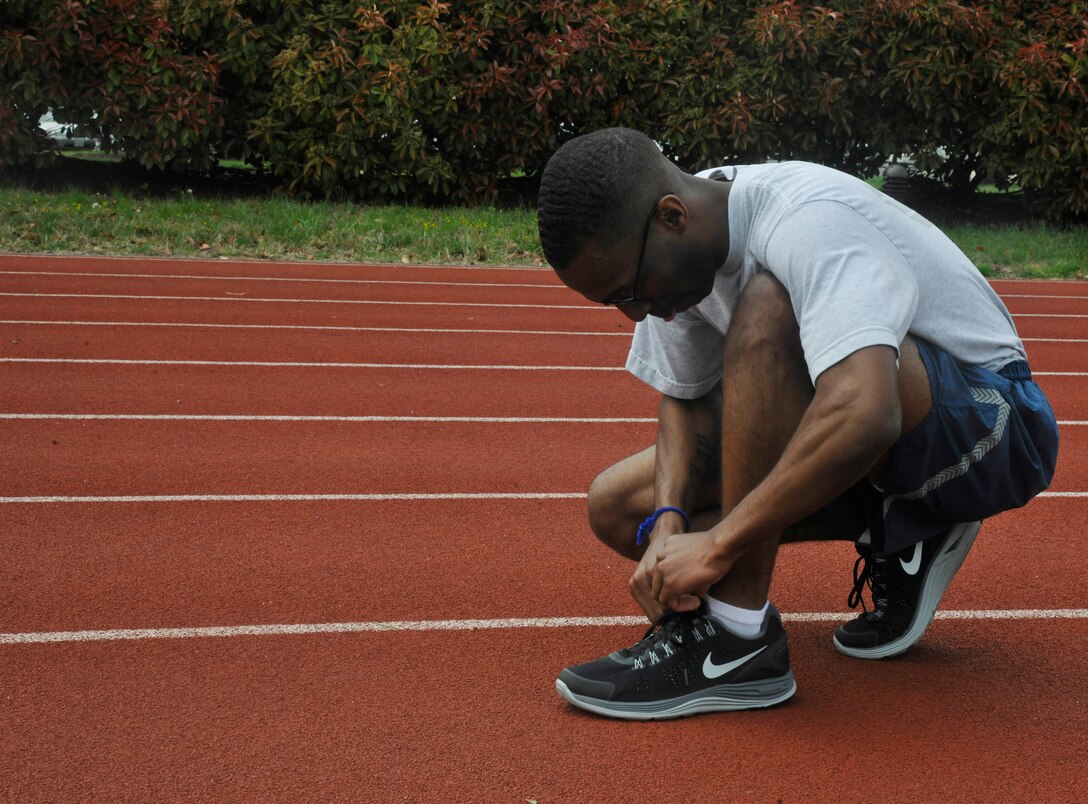 Senior Airman Anthony Lay, 11th Operations Group knowledge operator, prepares for his leg of a 100 meter relay race during an outdoor 11th Operations Group commander's call at Joint Base Anacostia-Bolling April 23, 2013. The commander's call was held in order to present the 11 OG's three units with their quarter and annual awards, raise money for the Air Force Assistance Fund, as well as build camaraderie and maintain the morale of all within each unit.   (U.S. Air Force photo/Senior Airman Lindsey A. Porter)