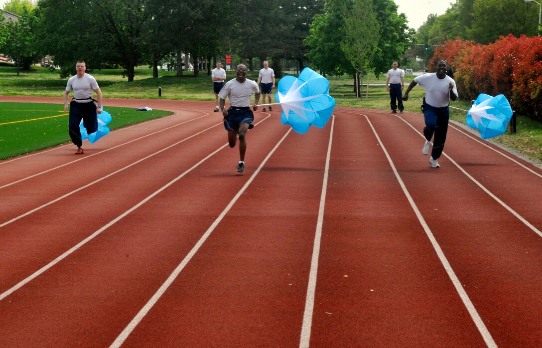 11th Operations Group Airmen participate in a parachute resistance relay race during an outdoor 11th Operations Group commander's call at Joint Base Anacostia-Bolling on April 23, 2013. The commander's call was held in order to present the group with their quarter and annual awards as well as afford the group a venue to raise money for the Air Force Assistance Fund and maintain camaraderie and morale within the unit. (U.S. Air Force photo/Senior Airman Lindsey A. Porter)
