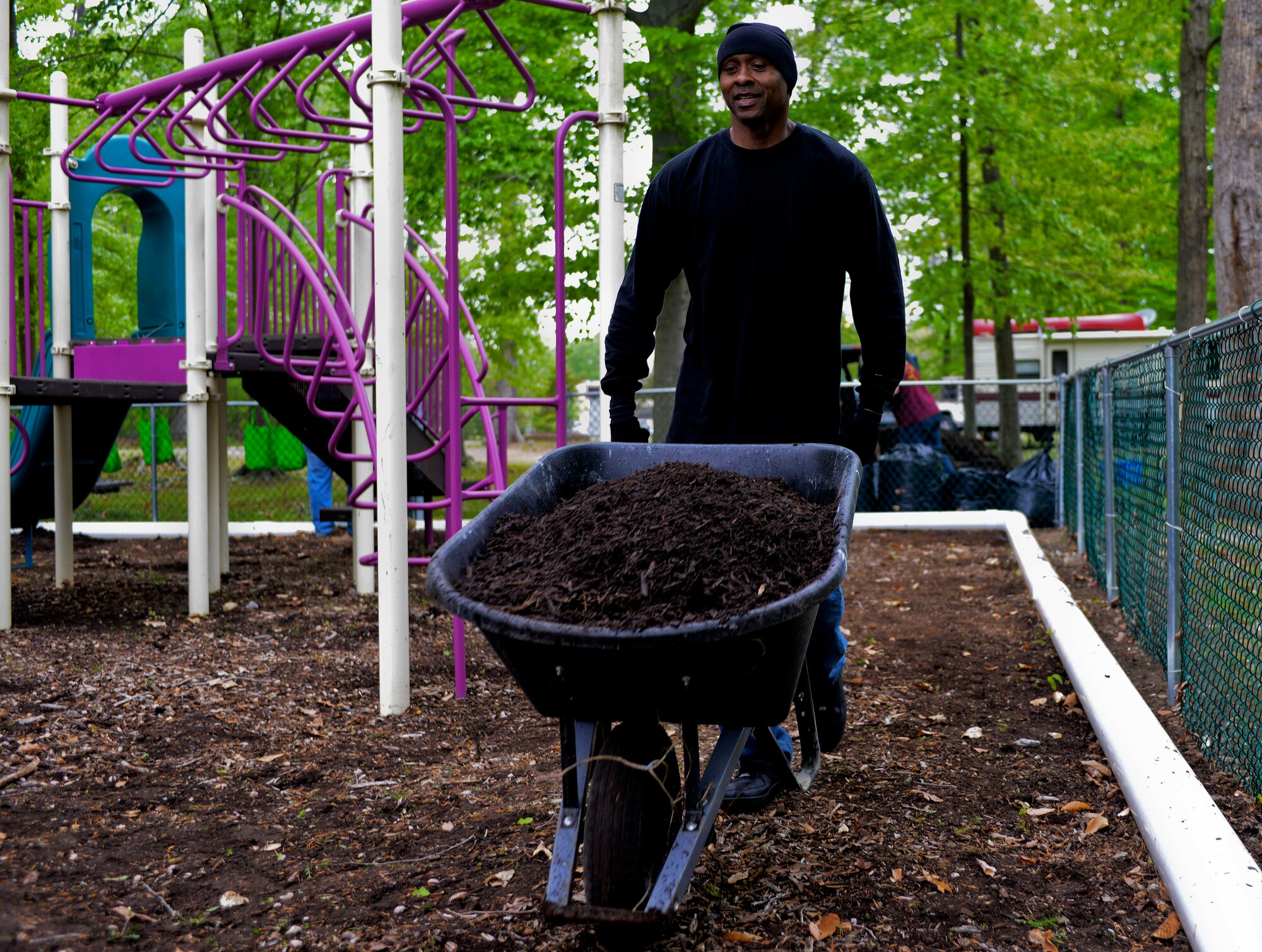 U.S. Army Sgt. 1st Class Andreas Fuller, 93rd Signal Brigade information systems operator, moves a wheelbarrow of mulch as part of the brigade’s effort in support of  Earth Week at Fort Eustis, Va., April 23, 2013. Other Earth Week projects included shoreline and tree plantings, woodland trail clean-up and maintenance, storm drain marker installation, preservation of historical areas and rain garden maintenance. (U.S. Air Force photo by Airman 1st Class R. Alex Durbin/Released)