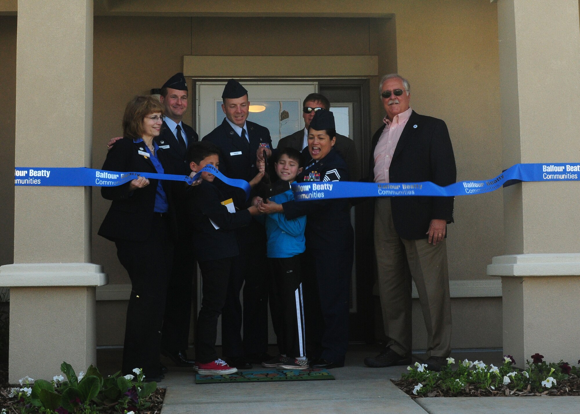 The Havens family (center) along with Col. Phil Stewart (back Left), 9th Reconnaissance Wing commander, and members of the Balfour Beatty Communities cut the ribbon on the Havens new home at Beale Air Force Base Calif., April 24, 2013. The Havens were the first family to move into their new home. (U.S. Air Force photo by Senior Airman Allen Pollard/Released)