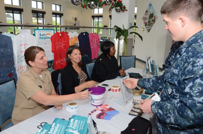 Navy Sexual Assault Prevention and Response victim advocate Lt. j.g. Amy Ellison, Naval Nuclear Power Training Command, Tiffany Mizzell, Joint Base Charleston - Weapons Station Sexual Assault Response Coordinator, and Chief Petty Officer Andrella Pusha, SAPR NNPTC victim advocate, discuss SAPR awareness with NNPTC students at the Joint Base Charleston - Weapons Station Galley, April 22, 2013. The SAPR informational awareness tables are just one of the many events designed to highlight and increase SAPR consciousness onboard the Weapons Station and throughout JBCharleston. (U.S. Navy photo/ Petty Officer 1st Class Chad Hallford)