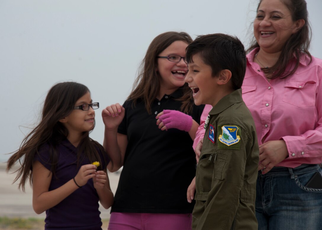 Daniel Gloria, honorary pilot for a day, laughs with his family during his tour of the flight line on Laughlin Air Force Base, Texas, April 17, 2013. The pilot for a day program gives terminally ill or disabled children the opportunity to experience a day in the life of a pilot. (U.S. Air Force photo/Airman 1st Class Jimmie Pike)