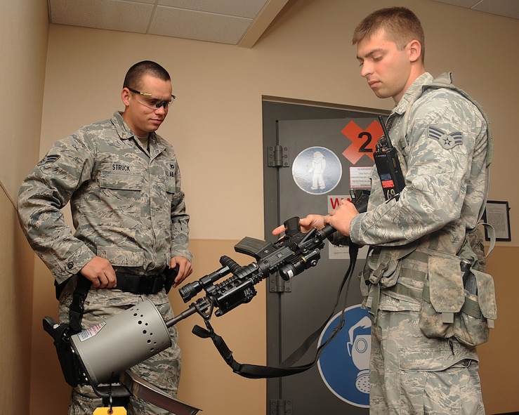 Senior Airman Marquis Barron-Glenn, 2nd Security Forces Squadron patrolman, clears his weapon as Senior Airman Keith Struck, 2 SFS patrolman looks on prior to shift change in the armory on Barksdale Air Force Base, La., April 24, 2013. The 2 SFS armory is in charge of issuing all equipment including weapons, ammunition, radios and asp batons to Airmen. (U.S. Air Force photo/Senior Airman Sean Martin)