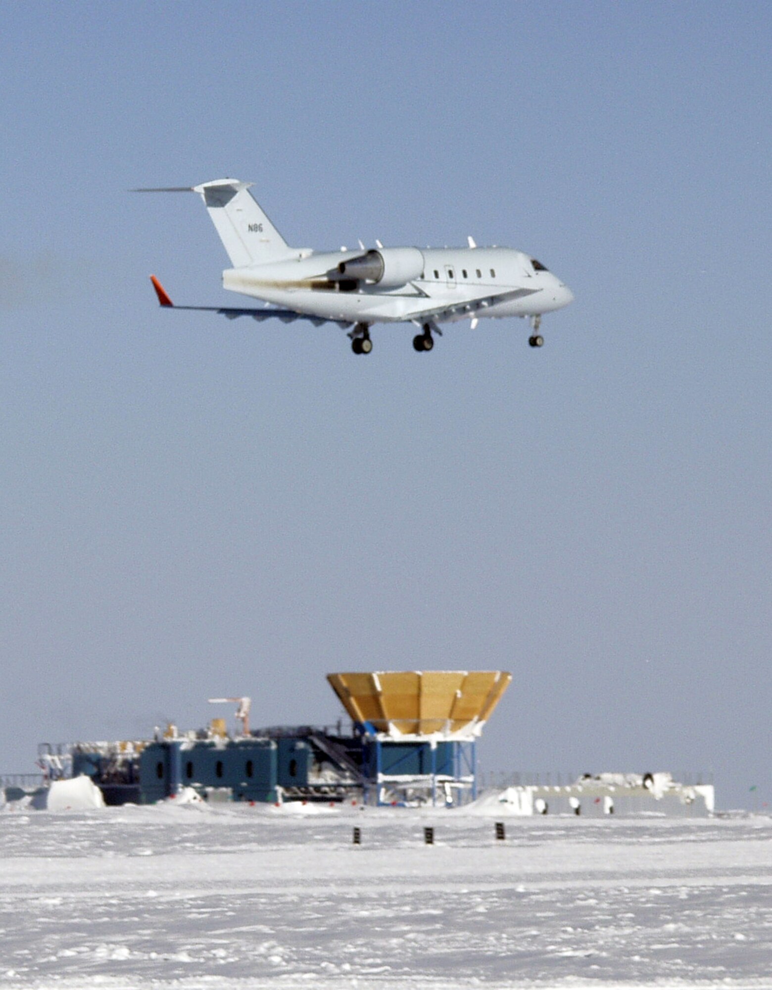 A Bombardier Challenger flown by a 1st Aviation Standards Flight crew, flies over McMurdo Station, Antarctica. The 1st ASF is a small team of reservists that are the only team in the world qualified to inspect McMurdo Station. (Courtesy Photo)   