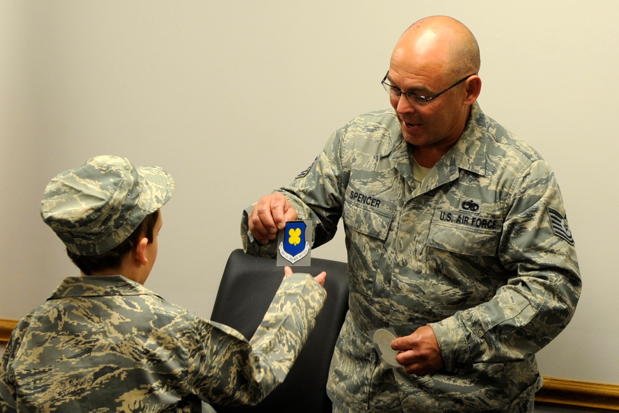 Tech. Sgt. James Spencer, crew chief, 307th Aircraft Maintenance Squadron presents a 307th Bomb Wing decal to Honorary Colonel Hunter Tomlin during ceremonies in Hangar 1 at Barksdale Air Force Base, La., April 24, 2013. Hunter, who has Neurofibromatosis Type 1, also known as von Recklinghausen disease, is recovering from surgery performed to remove a tumor from his face that hindered his ability to breathe through his nose. Members of the 307th AMXS and 2nd Aircraft Maintenance Squadron made Hunter’s dream come true by presenting him with an Air Force uniform, a tour of a B-52 Stratofortress and mementos of his visit to Barksdale. (U.S. Air Force photo by Master Sgt. Jeff Walston)