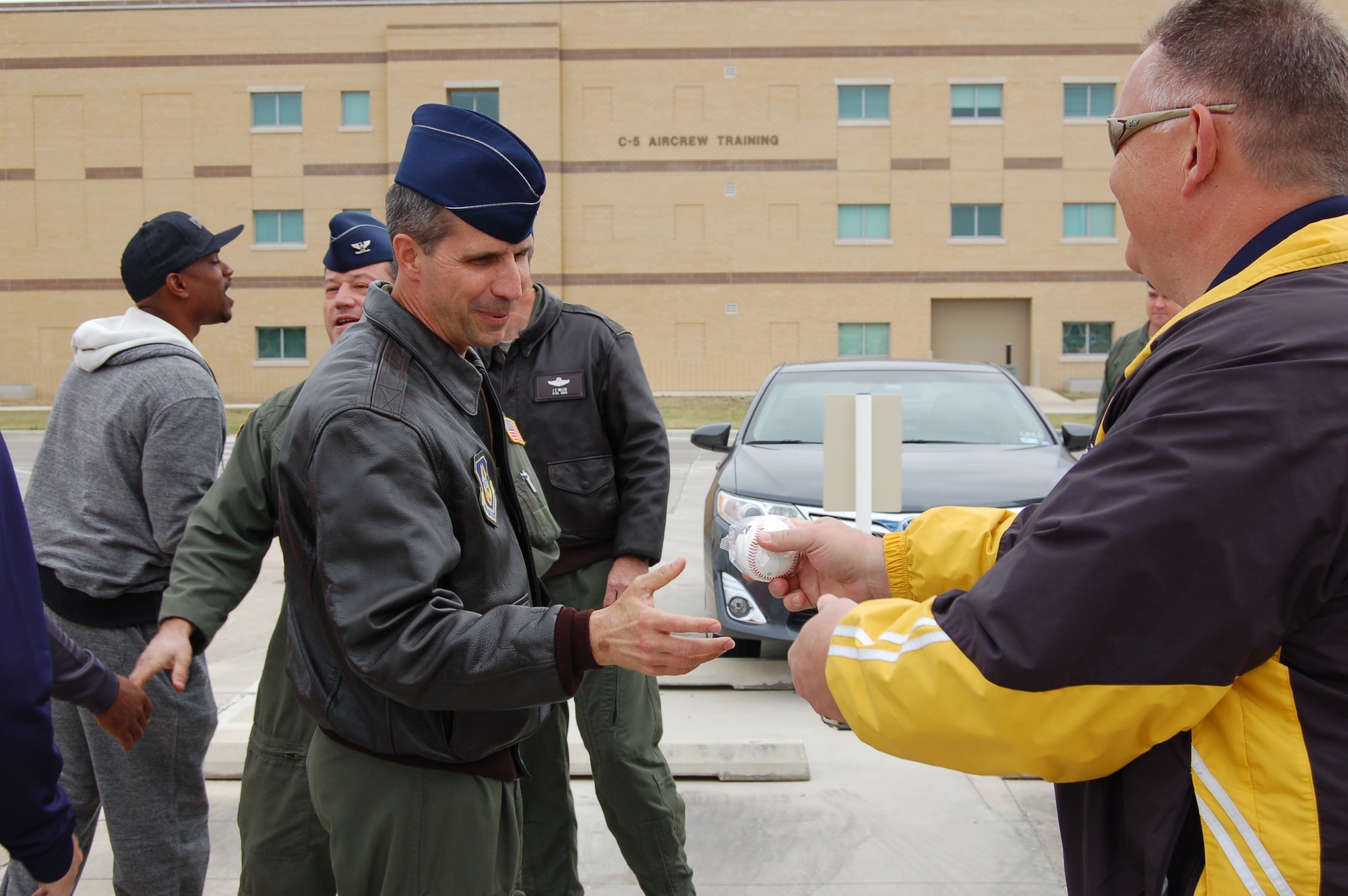 Col. Jeffrey T. Pennington, 433rd Airlift Wing commander, accepts a souvenir baseball from Bill Gerlt, 433rd Airlift Control Flight honorary commander, during a visit by Major League Baseball's San Diego Padres' General Manager Josh Byrnes and several former MLB players April 24 at Joint Base San Antonio-Lackland.  Gerlt is also the assistant general manager for the San Antonio Missions baseball team, a Class AA affiliate of the San Diego Padres. (U.S. Air Force Photo/Elsa Martinez)