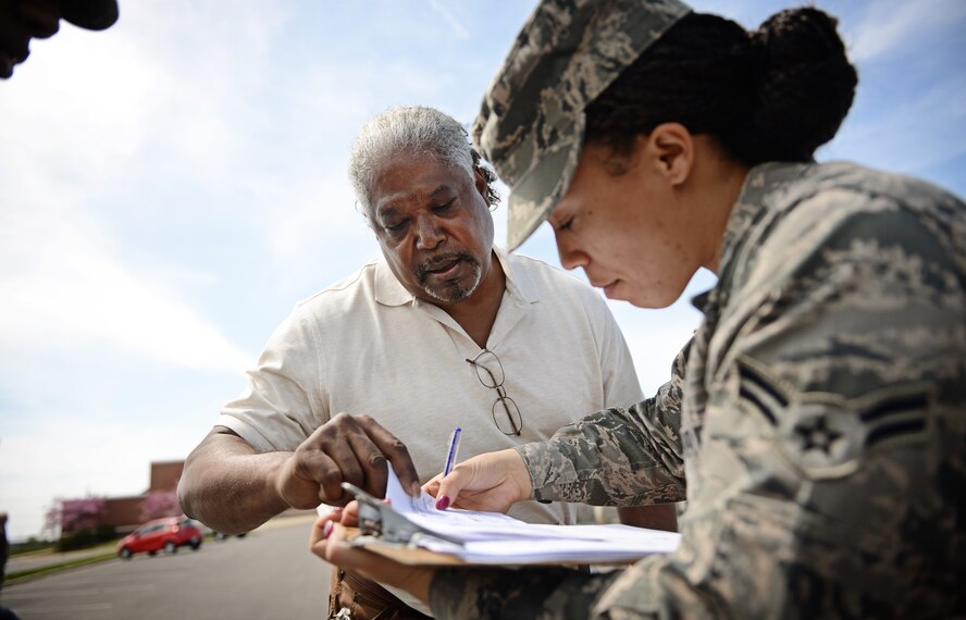 Airman 1st Class Jacy Carpenter, 375th Air Mobility Wing legal assistant, assists a government employee on Scott Air Force Base with a damage to personal property claim April 22, 2013, following severe weather which caused flooding in many areas on base. Due to the massive flooding on base the legal office was able to have the area declared as an "unusual event" allowing people to file claims with the Air Force Claims Service Center.(U.S. Air Force photo/ Staff Sgt. Ryan Crane)