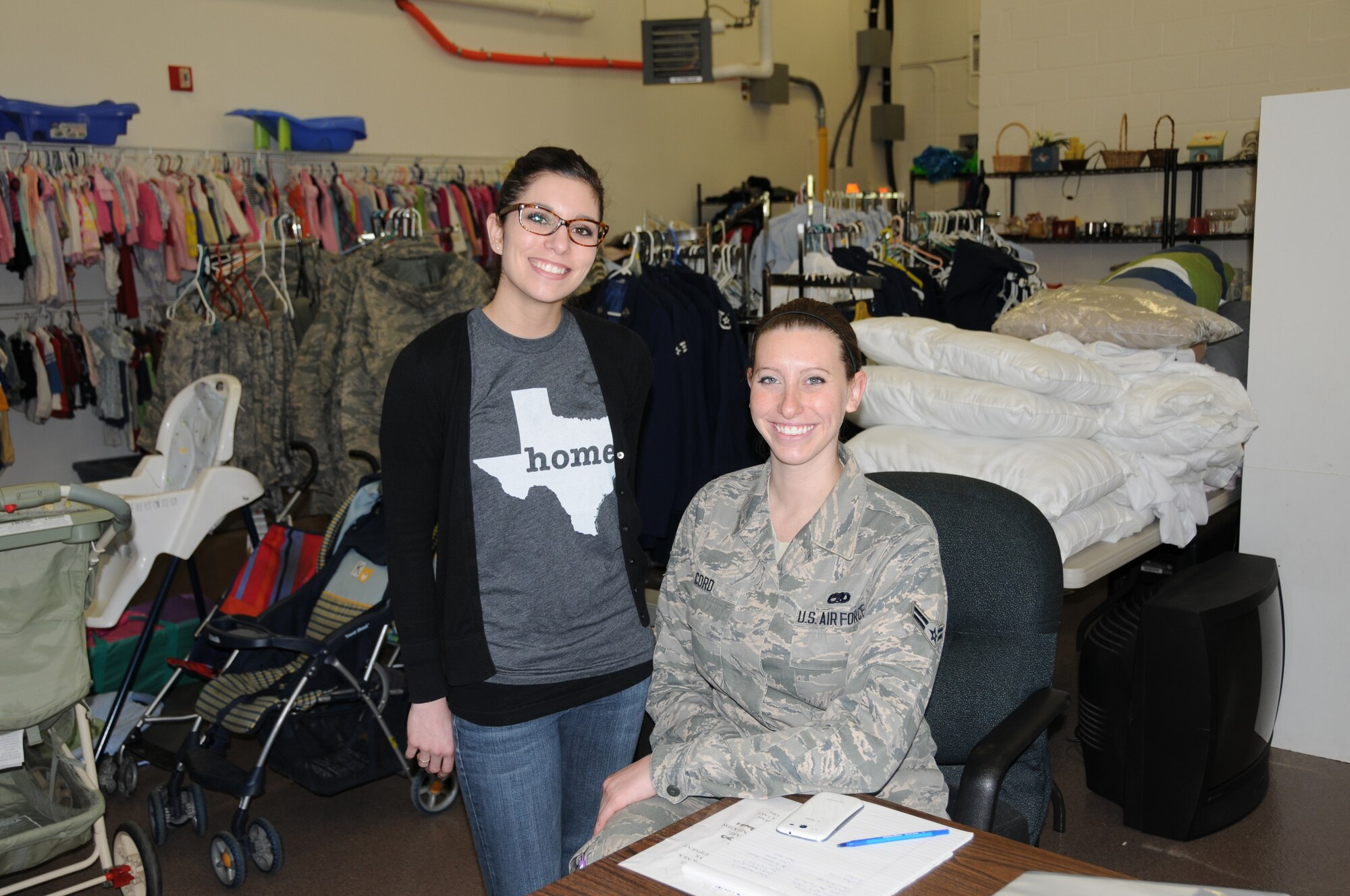 Lauren Gaylord (left) and Airman 1st Class Lori Cord are volunteers who spend several hours on Wednesdays assisting patrons in choosing items from among the numerous donated items at the Airman's Attic, Dover Air Force Base, Del. Other duties of a volunteer include sorting through new donations and organizing them onto display racks. (U.S. Air Force photo/Senior Airman Joe Yanik)