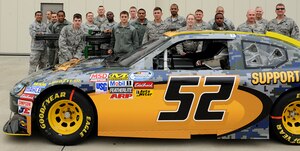U.S. Air Force Airmen from the 1st Maintenance Squadron pose behind a former NASCAR competition vehicle at Langley Air Force Base, Va., April 24, 2013. Blake Koch, Nationwide driver of the #24 SupportMilitary.org NASCAR vehicle, visited Langley prior to competing in the Spring Cup Series race in Richmond, Va. (U.S. Air Force photo by Airman 1st Class Kimberly Nagle/Released)
