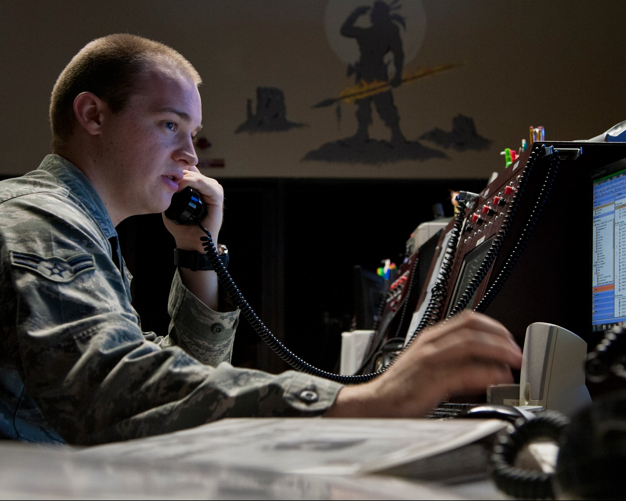 ALTUS AIR FORCE BASE, Okla. -- Airman 1st Class Hans Koenig, 97th Air Mobility Wing Command Post emergency actions controller, speaks on the phone inside the command post, April 24. The members of the 97th AMW CP, copy, validate, and relay time-critical Air Education and Training Command Emergency Action messages. They also implement Quick Reaction Checklists in response to contingency operations, and coordinate activities with 11 base agencies for mobility aircraft. (U.S. Air Force photo by Senior Airman Kenneth W. Norman)