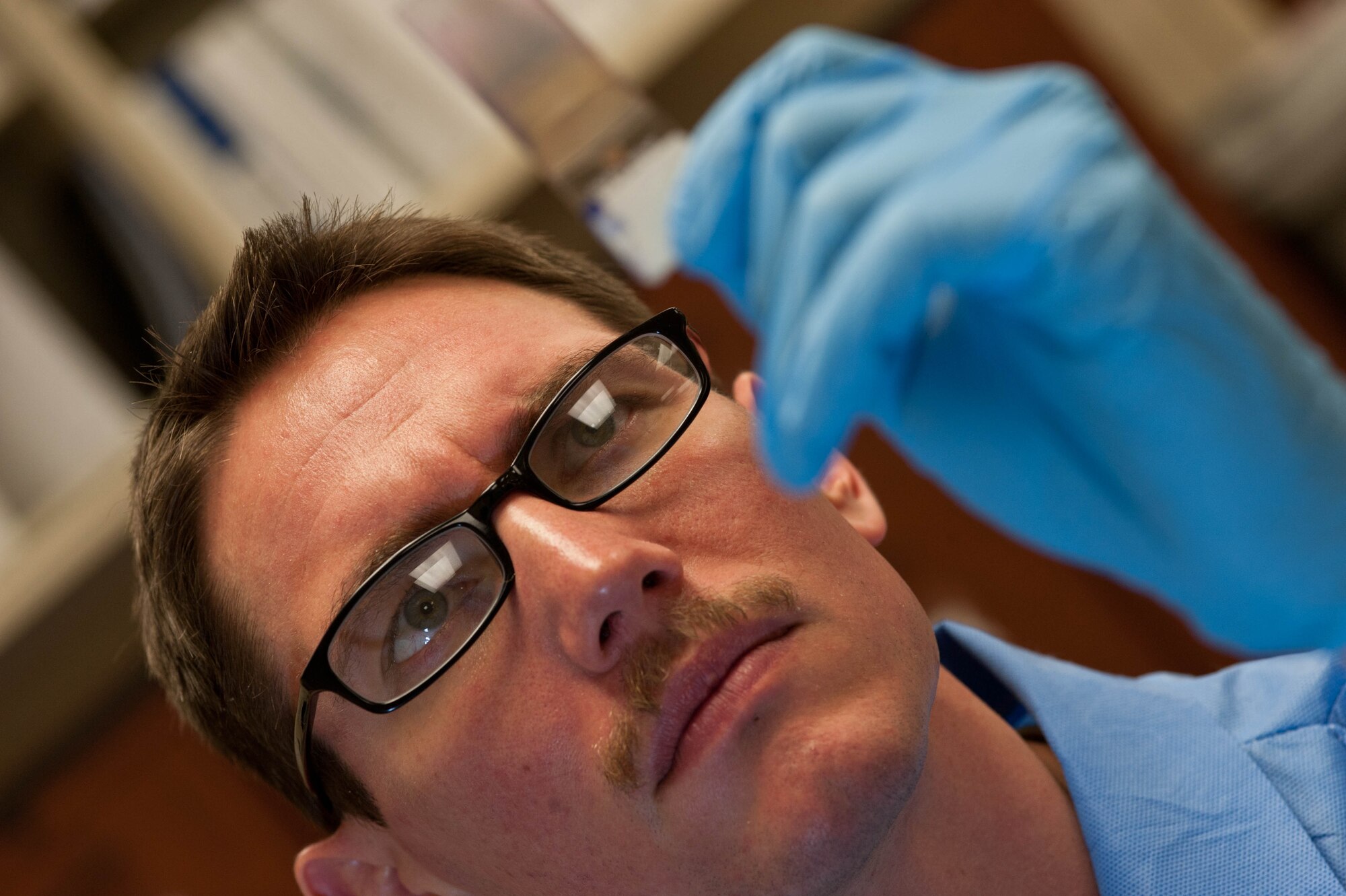 Senior Airman Lance Gillenwater, 28th Medical Support Squadron medical laboratory technician, examines a smeared blood slide in the clinical laboratory at Ellsworth Air Force Base, S.D., April 19, 2013. On average, the lab reviews samples of more than a 100 active-duty military members and their dependents each day. (U.S. Air Force photo by Airman 1st Class Zachary Hada/Released)