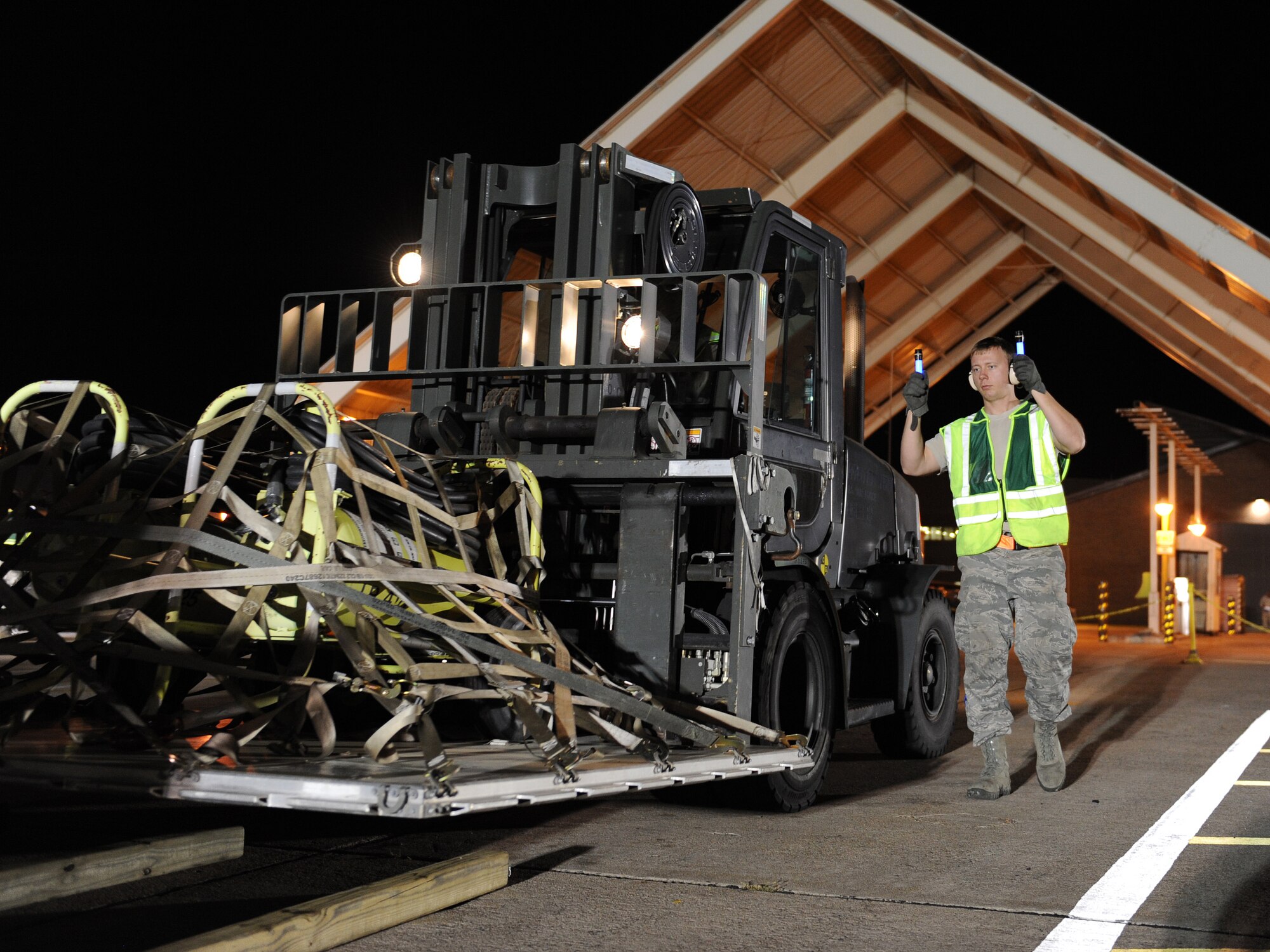 Senior Airman Brandon Poling, a 19th Logistics Readiness Squadron air transportation specialist, marshals a Hyster 10K forklift driven by Senior Airman Michel Clement, a 19th LRS vehicle mechanic, April 23, 2013, at Little Rock Air Force Base, Ark.  Poling and Clement placed the equipment pallets in sequencing order for loading and transport to simulated C-130 aircraft during the ROCKEX training exercise. (U.S. Air Force photo by Tech. Sgt. Chad Chisholm)