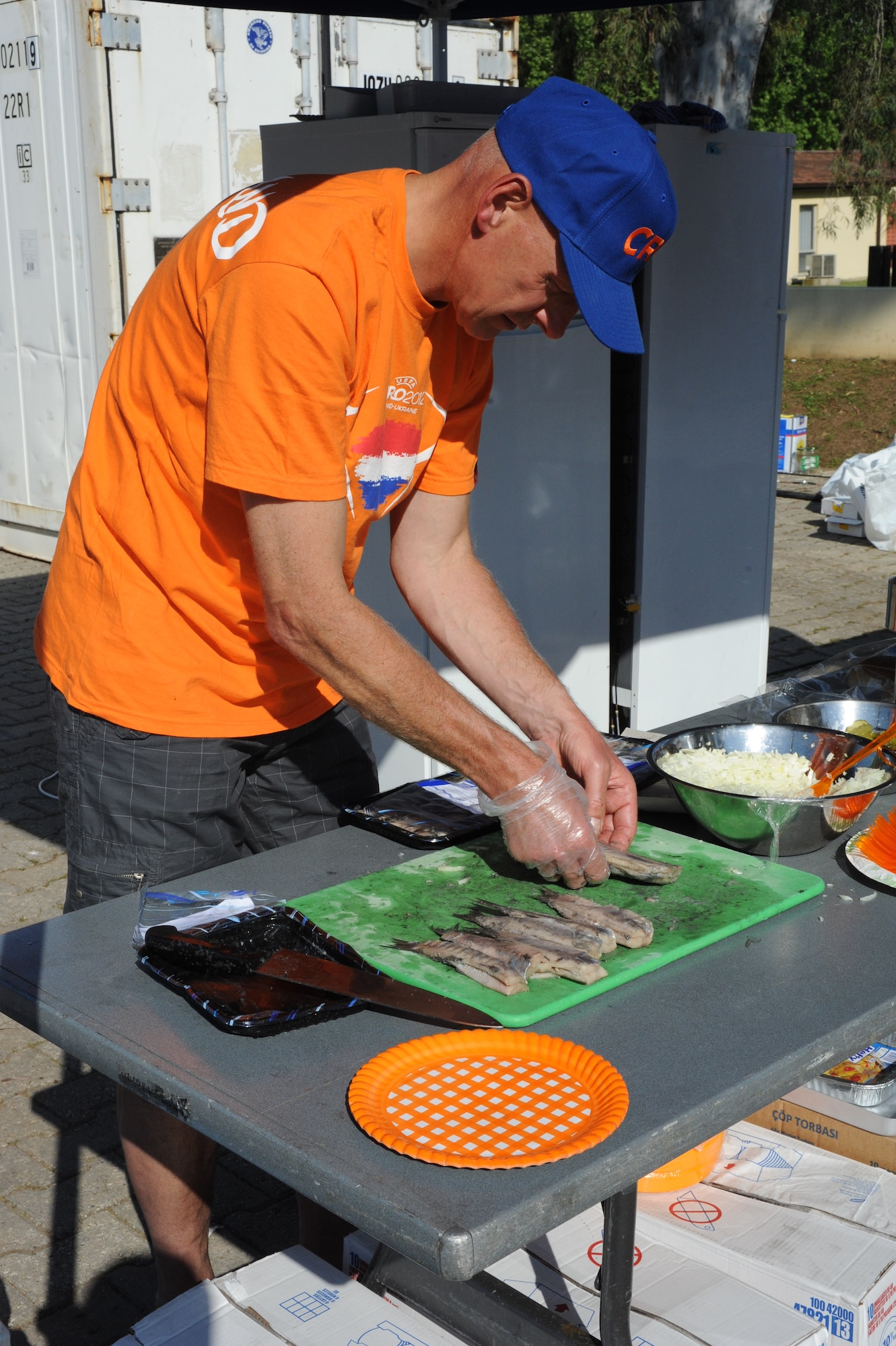 A soldier from the Dutch army prepares raw herring, a typical Dutch food called maatjesharing, during Koninginnedag, or Queen’s Day, celebration held at Arkadas Park April 25, 2013, Incirlik Air Base, Turkey. The Dutch invited U.S. and Turkish personnel to attend the event that included Dutch food, a touwtrekken toernooi (tug-of-war tournament), live music and a bonfire. (U.S. Air Force photo by 1st Lt. David Liapis/Released)