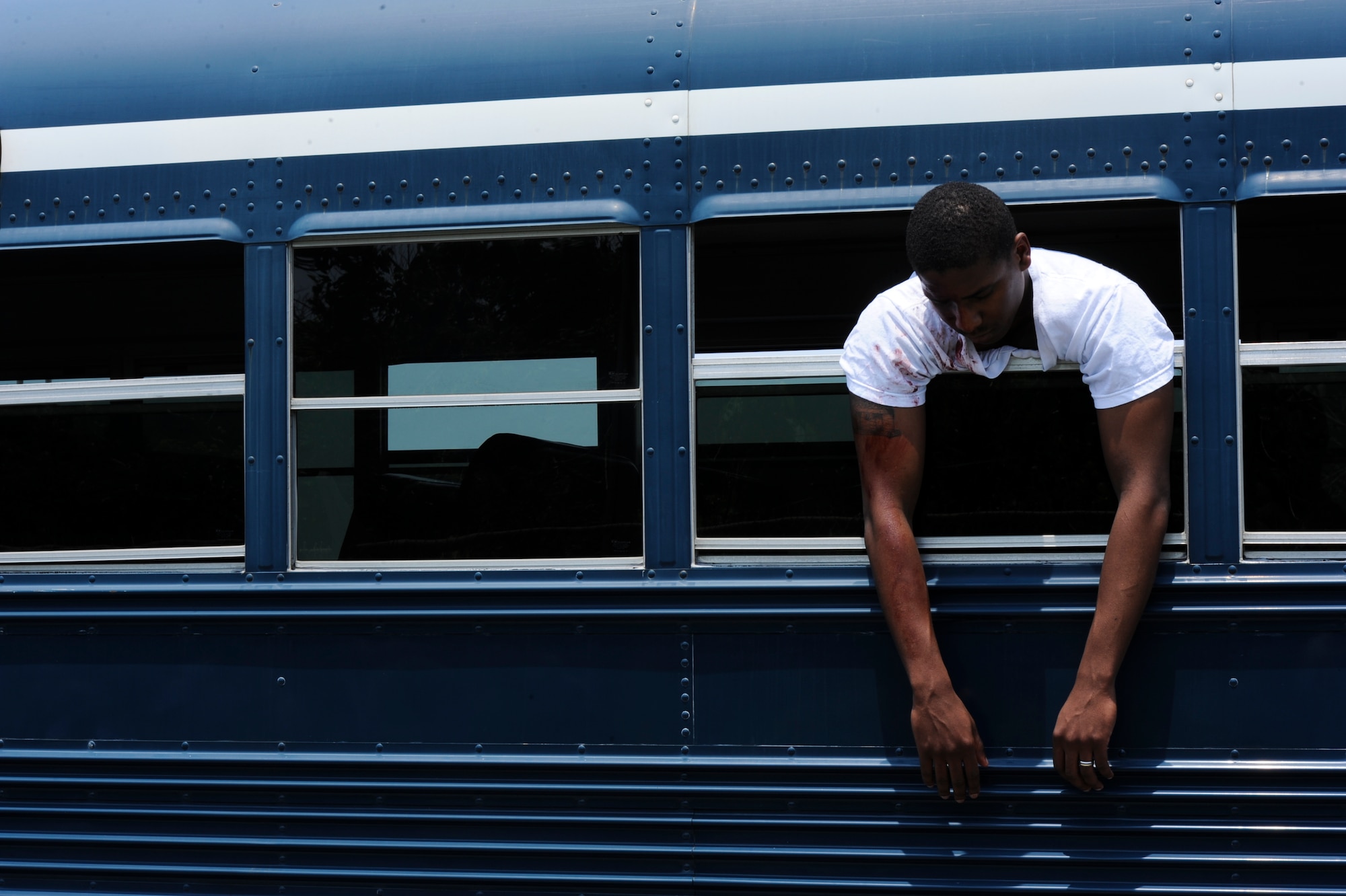 A simulated victim hangs out the window of a tour bus during an emergency management exercise on Kadena Air Base, Japan, April 25, 2013. EME scenarios like these allow for emergency response training keeping the skills of Kadena's Airmen honed and ready for any possible crisis situation. (U.S. Air Force photo by Airman 1st Class Justin Veazie/Released)