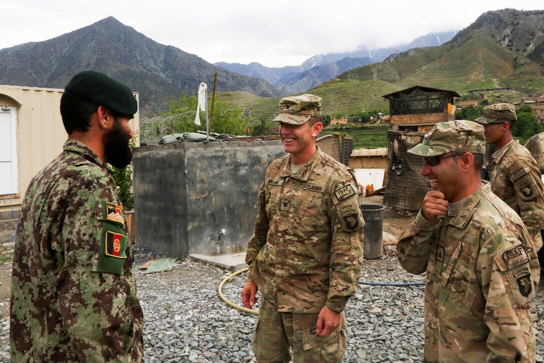 U.S. Army Col. J.P. McGee, center, speaks with an Afghan soldier during a meeting on Forward Operating Base Bostic, Kunar province, Afghanistan, April 20, 2013. McGee is commander, 101st Airborne Division's 1st Brigade Combat Team.
