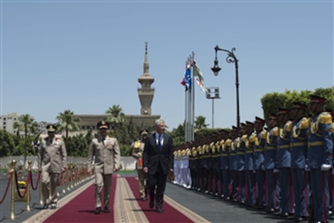Egyptian Minister of Defense Abdel Fatah Saeed Al Sisy, center, escorts Secretary of Defense Chuck Hagel, right, as he inspects the troops during an arrival ceremony in Cairo, Egypt, on April 24, 2013.  Egypt is Hagel's fourth stop on a six-day trip to the Middle East to meet with defense counterparts.  