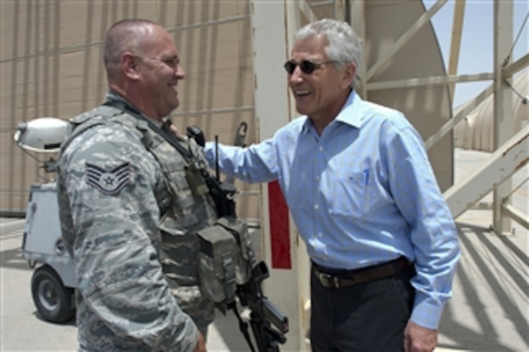 Secretary of Defense Chuck Hagel laughs with a U.S. Air Force staff sergeant providing security while Hagel visits troops at an undisclosed location in Southwest Asia on April 25, 2013.  Hagel thanked the troops for their service and answered various questions including those on the effects of sequestration on the Air Force as well as sanctions on Iran.  