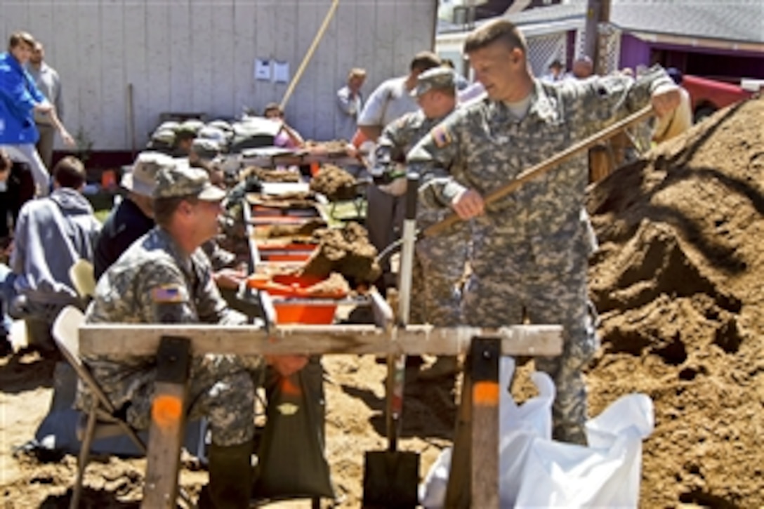 Soldiers fill sandbags during flood relief efforts in Clarksville, Mo., April 20, 2013. The soldiers are Missouri Army National Guardsmen assigned to the 2175th Military Police Company. Coast Guard, Army Corps of Engineers and National Guard units responded to major flooding along rivers in the Midwest. 