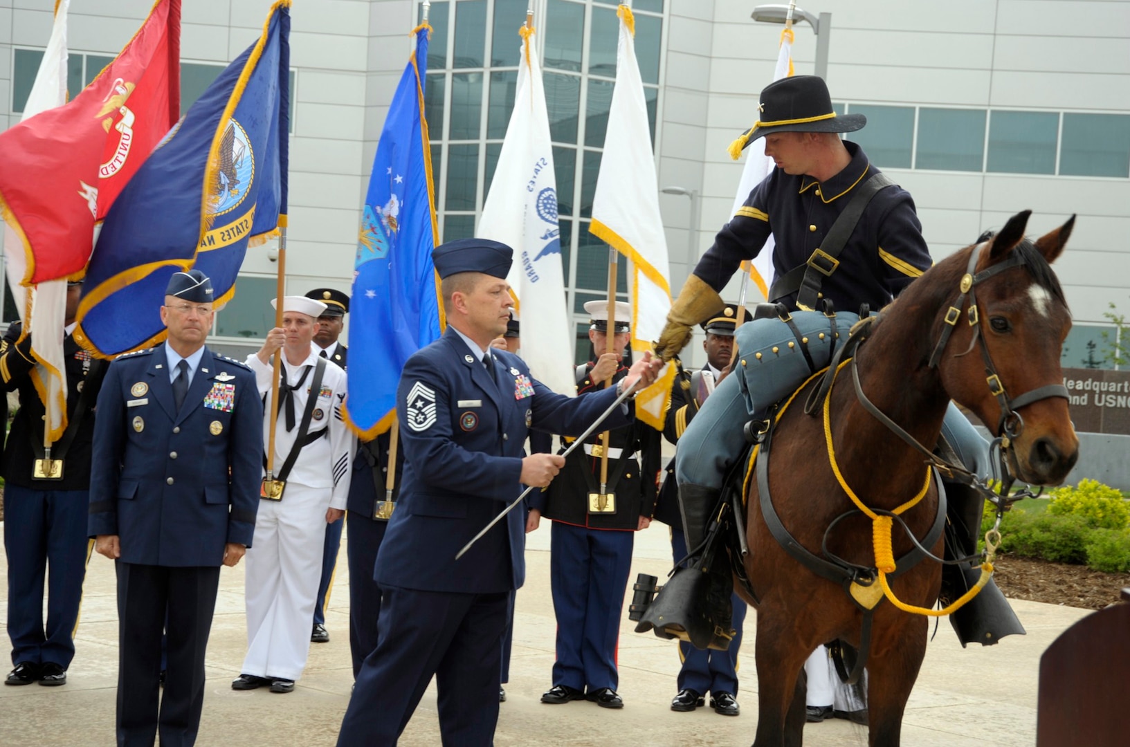 Command Chief Master Sgt. W. Allen Usry, NORAD and U.S. Northern Command command senior enlisted leader, hands the Noncommissioned Officer's Sword to a member of the Fort Carson Mounted Color Guard during the May 21 NORAD and U.S. Northern Command's Change of Responsibility ceremony at Peterson Air Force Base, Colo. The sword is a symbol of the ability and prestige of enlisted leaders in the commands. The command sergeant major-as the senior enlisted leader- is the keeper of tradition for the unit. The emblematic passing of the sword of office signifies the transfer of this sacred trust from one command senior enlisted leader to another.