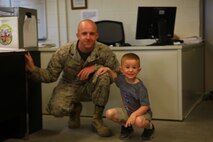 Cpl. Adam W. Weybrew, a motor vehicle operator with Combat Logistics Battalion 22, 2nd Marine Logistics Group, poses for a photo with his son during the Take your child to work holiday aboard Camp Lejeune, N.C., April 25, 2013. This was this second year that CLB-22 participated in the holiday. (U.S. Marine Corps photo by Lance Cpl. Shawn Valosin)
