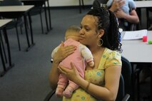Karla Smith, Baby Boot Camp class participant practices different methods of holding a baby during the Baby Boot Camp class April 18. The Baby Boot Camp class covers a wide array of what to expect during pregnancy and after the baby is born as well as answering any questions parents of future parents may have in a judgment-free environment.