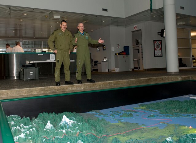 Colonel Bill Veenhof (right), Air Component Commander of Joint Task Force Games, briefs North American Aerospace Defense Command (NORAD) Deputy Commander Lieutenant-General Marcel Duval (left) about air operations for the Olympics using a floor-based map at the Integrated Security Unit Headquarters in Richmond, B.C.

Operation PODIUM is the Canadian Forces (CF) contribution to the overall security of the Vancouver 2010 Olympic and Paralympic Winter Games in support of the Royal Canadian Mounted Police (RCMP). The Air Force’s contribution is two-fold: The Air Component Command of Joint Task Force Games, which provides airlift, medical evacuation and area surveillance for the RCMP, and NORAD, which will ensure airspace security. 

In preparation for the Games, security and public safety agencies from all levels of government are working together to ensure they are prepared to respond to any potential emergency on land, sea or in the air. The scope and scale of these Games will make it the largest domestic security operation to date in Canadian history.

