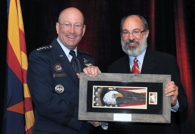 PHOENIX – Air Force Gen. Gene Renuart, North American Aerospace Defense Command and U.S. Northern Command commander, accepts a memento from Dr. Ken Farmer, Executive Vice President and Chief Operating Officer of Triwest Healthcare Alliance, during the American Red Cross Community Leader Breakfast in Phoenix, April 22. Renuart was the keynote speaker at the event, an annual gathering of business, government and philanthropic leaders to raise money and awareness for the Red Cross Grand Canyon Chapter. 

(Courtesy photo)