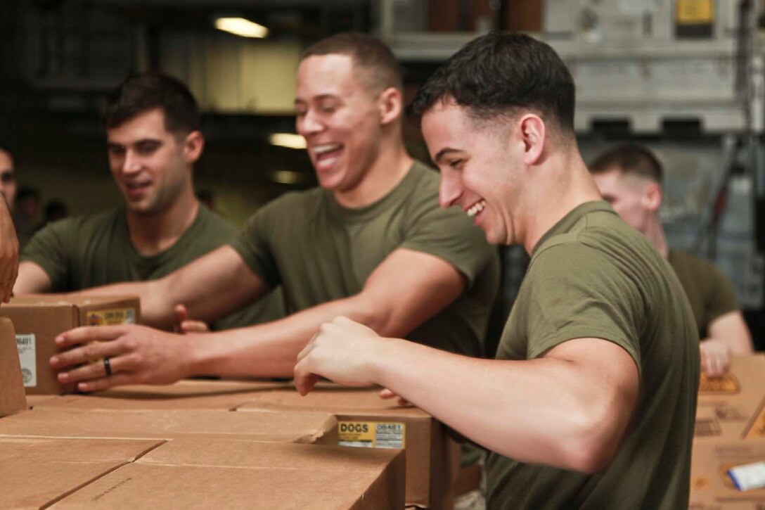 Corporal James E. Stires, unit movement control coordinator, 15th Marine Expeditionary Unit, shares a laugh with his fellow Marines while unloading boxes during a replenishment at sea on USS Peleliu, April 22. The 15th Marine Expeditionary Unit is deployed as part of the Peleliu Amphibious Ready Group and is comprised of approximately 2,400 Marines and sailors. Together with Amphibious Squadron Three, they provide a forward-deployed, flexible sea-based Marine Air Ground Task Force capable of conducting a wide variety of operations ranging from humanitarian aid to combat. Stires, 21, is from Wichita Falls, Texas. (U.S. Marine Corps photo by Cpl. John Robbart III/Released)