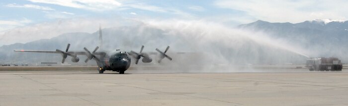 Air Force Gen. Gene Renuart, North American Aerospace Defense Command and U.S. Northern Command, taxis a 302nd Airlift Wing C-130 beneath arcs of water fired from Peterson AFB Fire Department fire trucks at the end of his final flight May 5. (U.S. Air Force photo by Staff Sgt. Thomas J. Doscher)